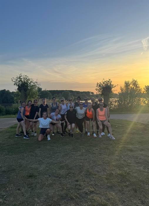 Groepsfoto na een bootcamp bij zonsondergang aan het water